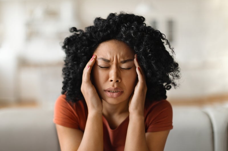 Woman grasping temples in pain