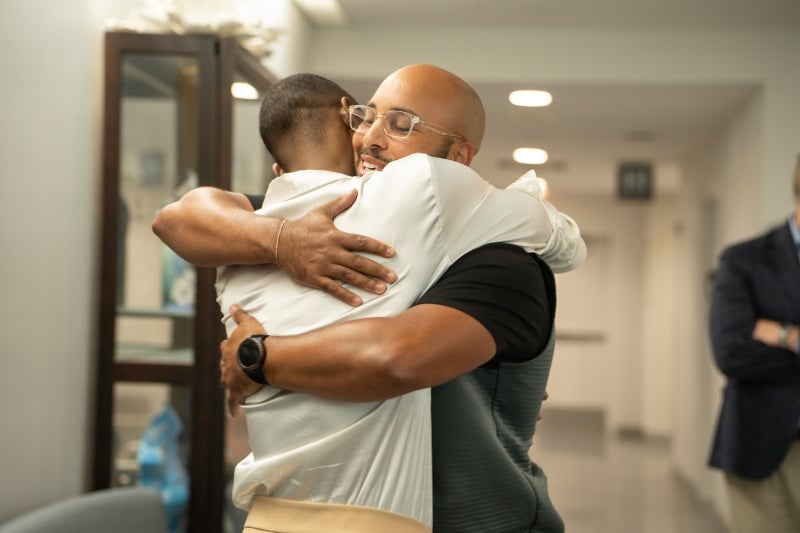 Damon and Syeed hug