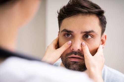Doctor inspecting man's sinuses