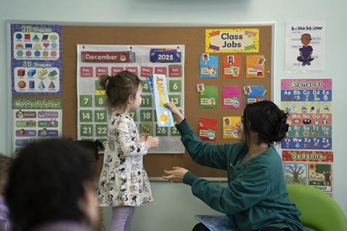 An adult introduces a toddler to their ABCs and numbers