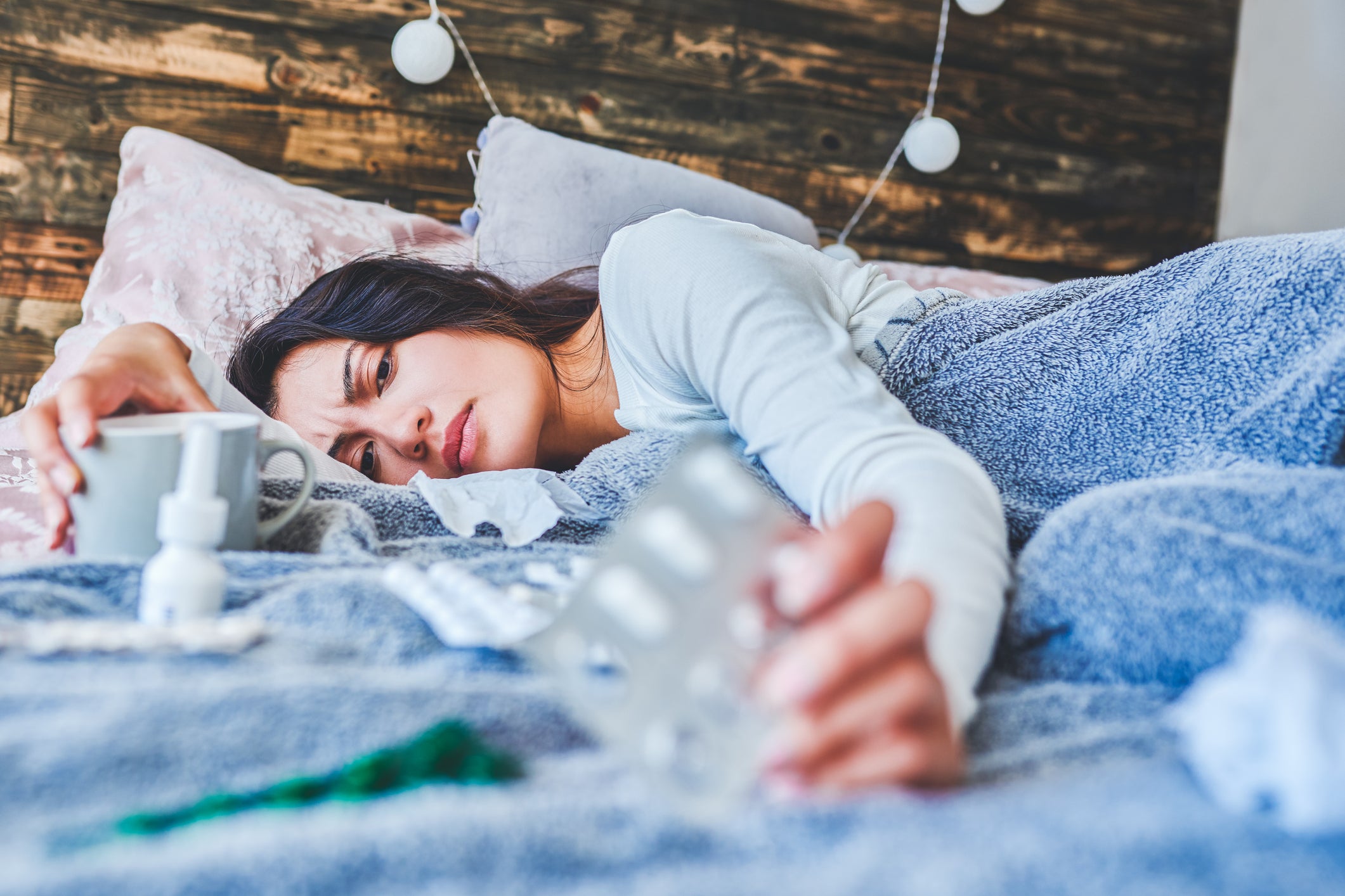 Woman laying in bed feeling sickly
