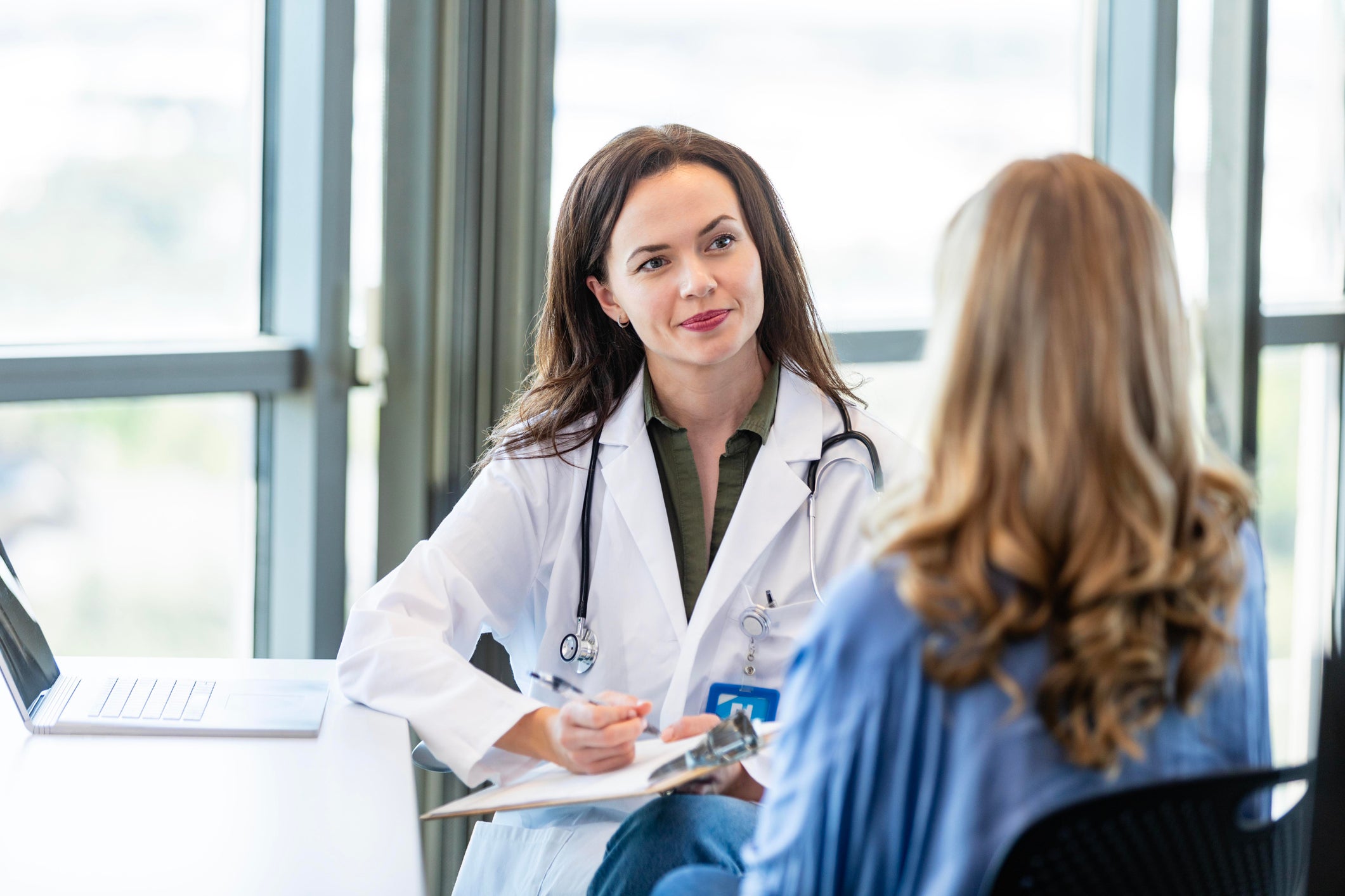 A nurse practioner attentively listening her her patient
