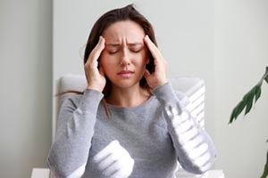 Woman holding her head in pain