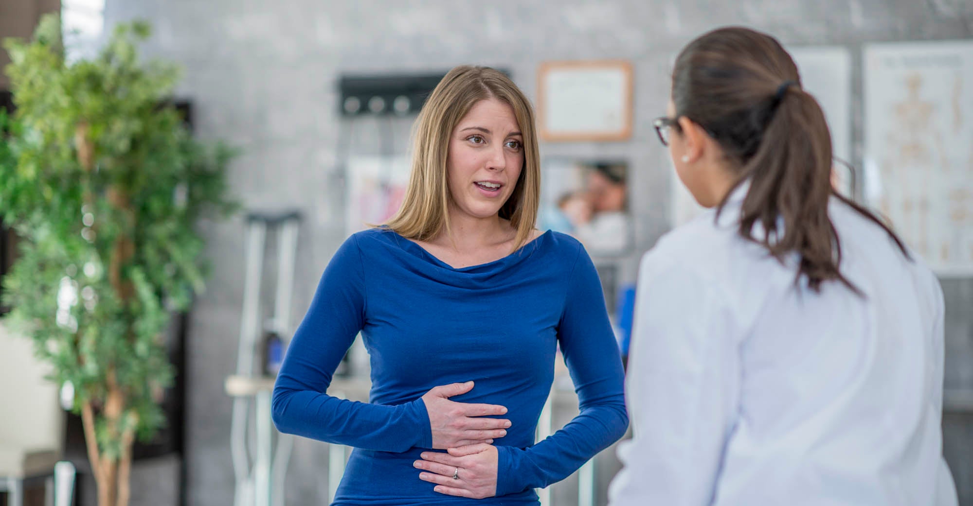 Woman with stomach pain talking to her provider
