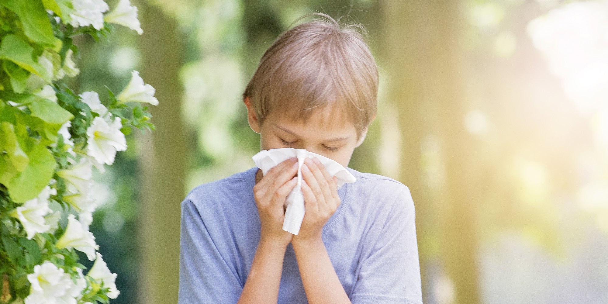 Child blowing nose outside