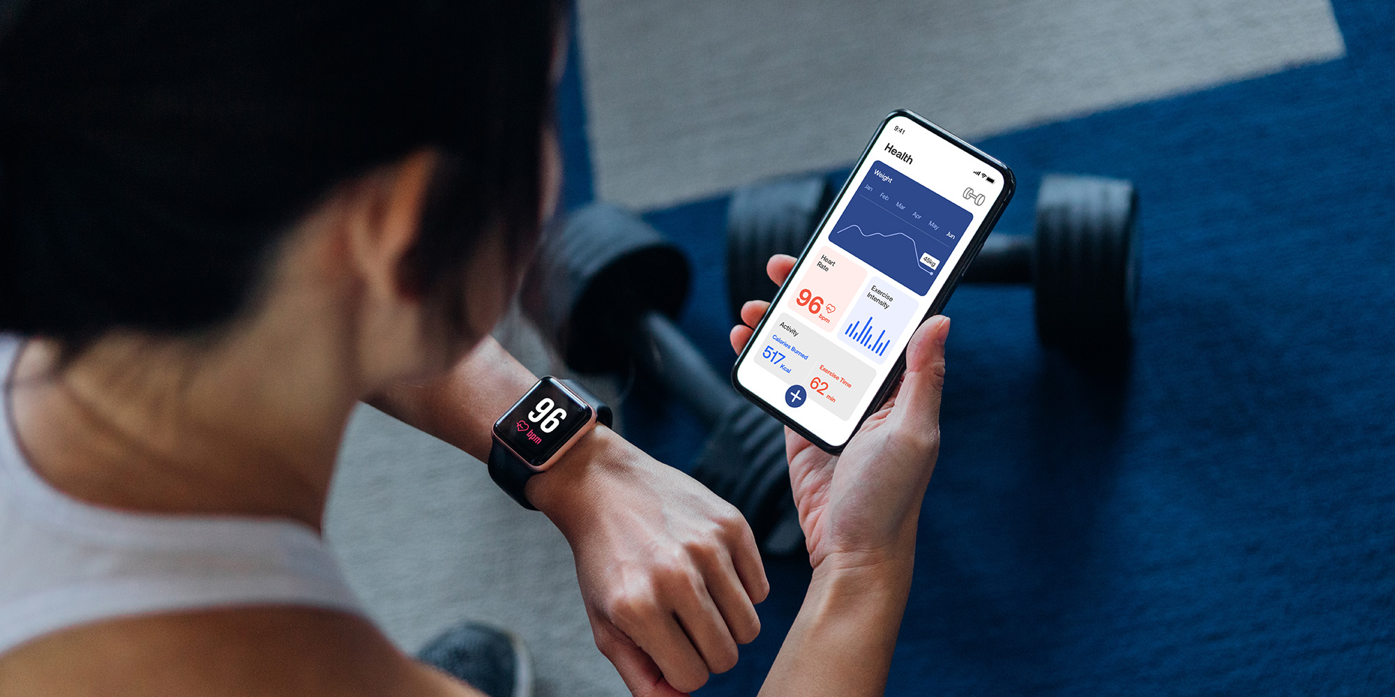 Person checking fitness watch and fitness app on smartphone