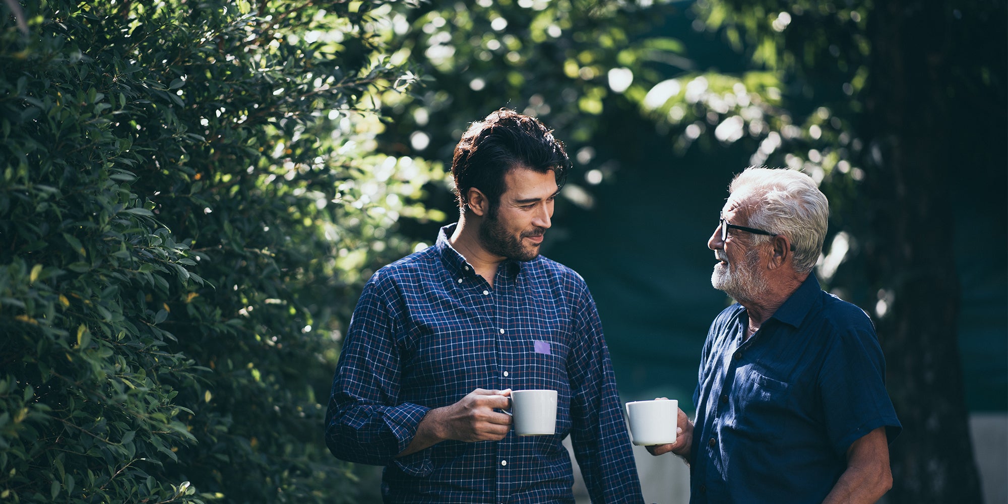 Two men drinking coffee outside