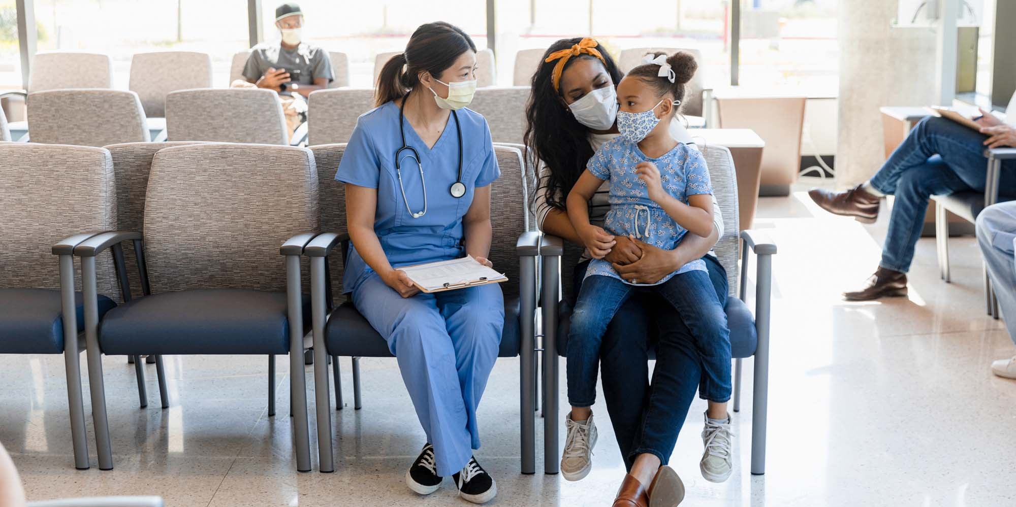 Provider talking to patients in a waiting area