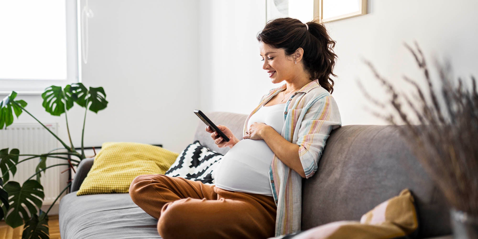 Pregnant woman reading on her couch