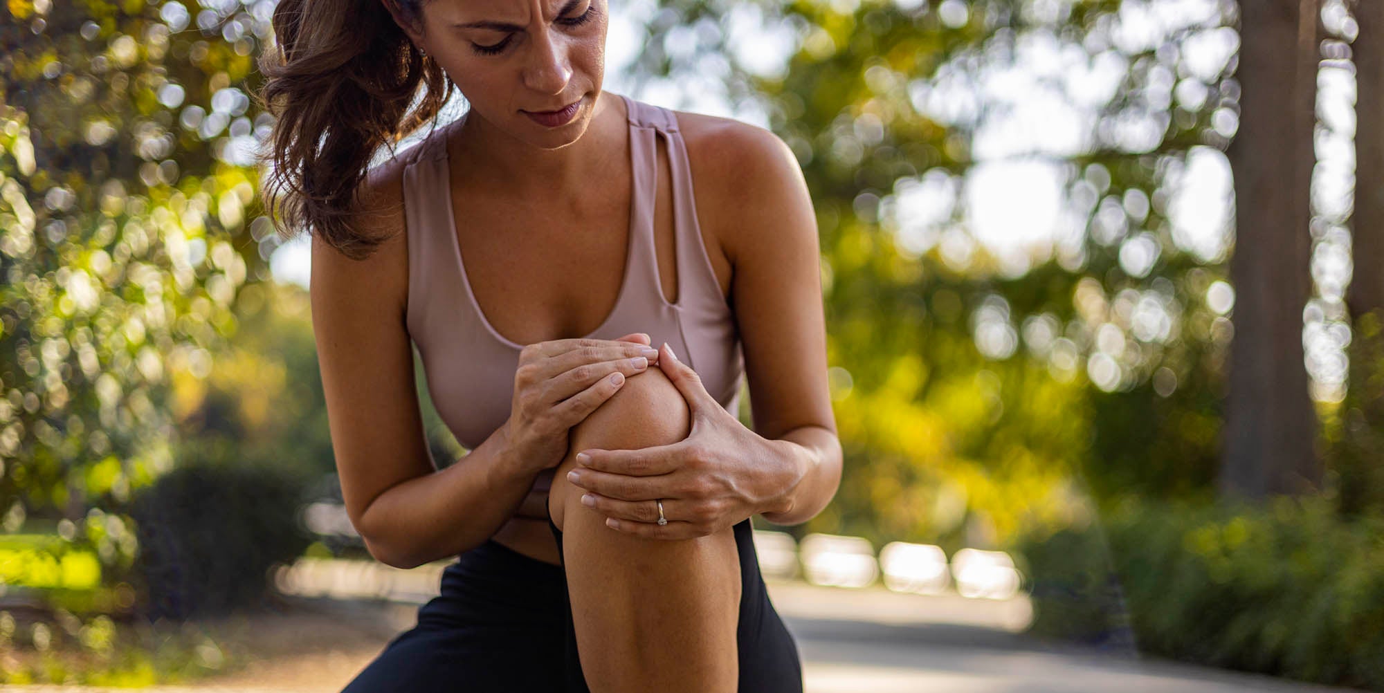Woman athlete holding her knee